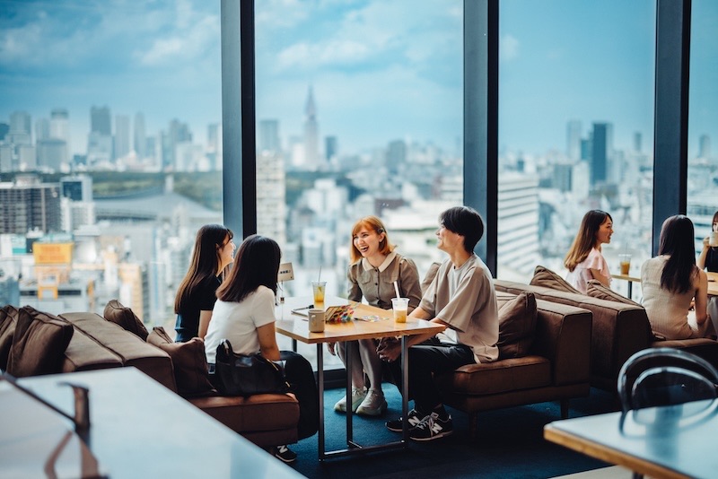 A group English conversation lesson at a cafe with a city view